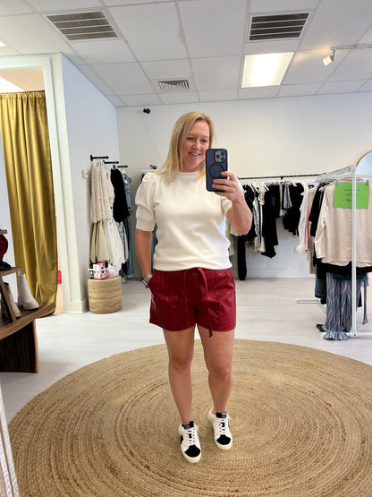 White sweater with red leather shorts